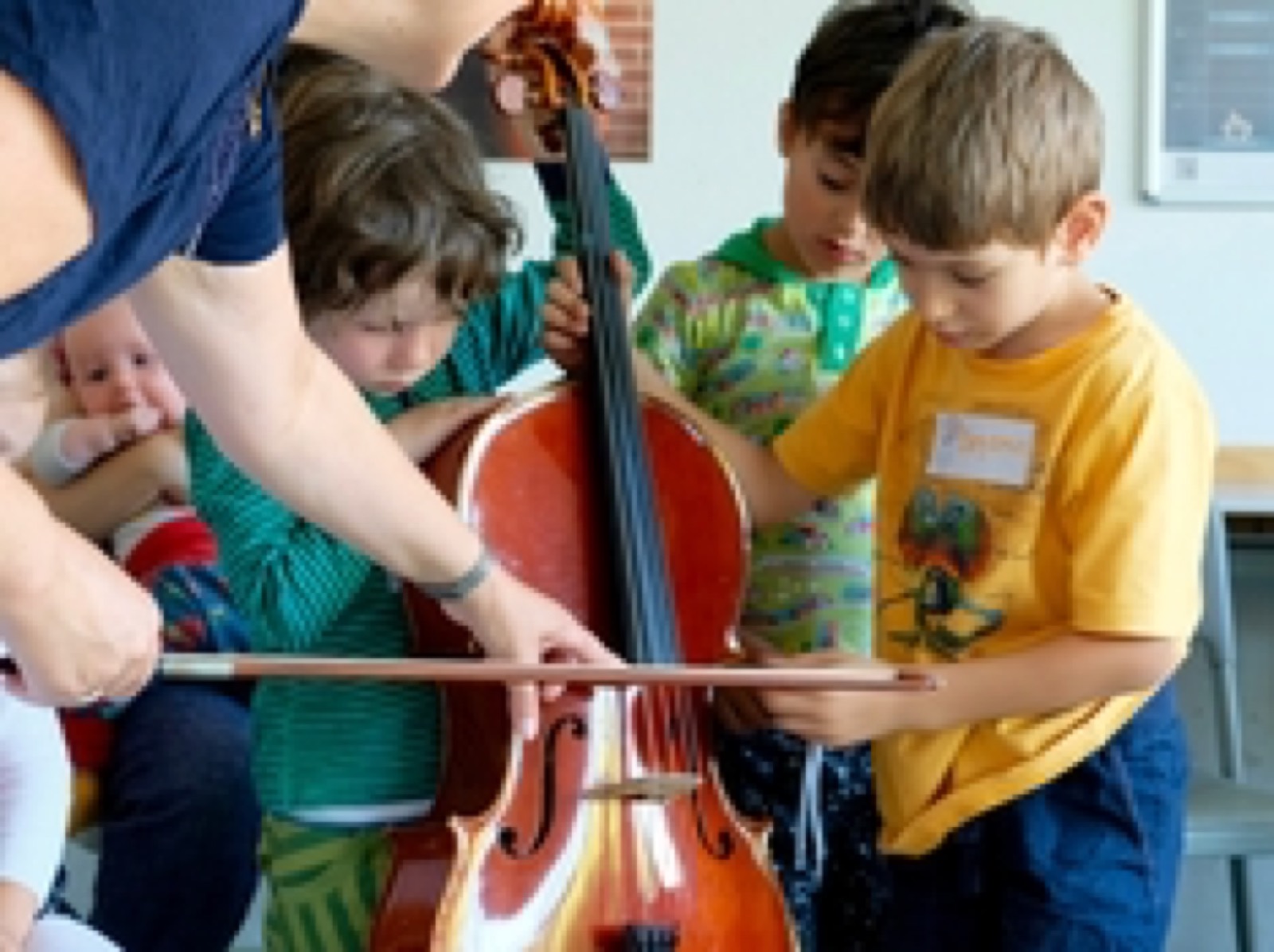 Des enfants essaient le violoncelle et l'archet